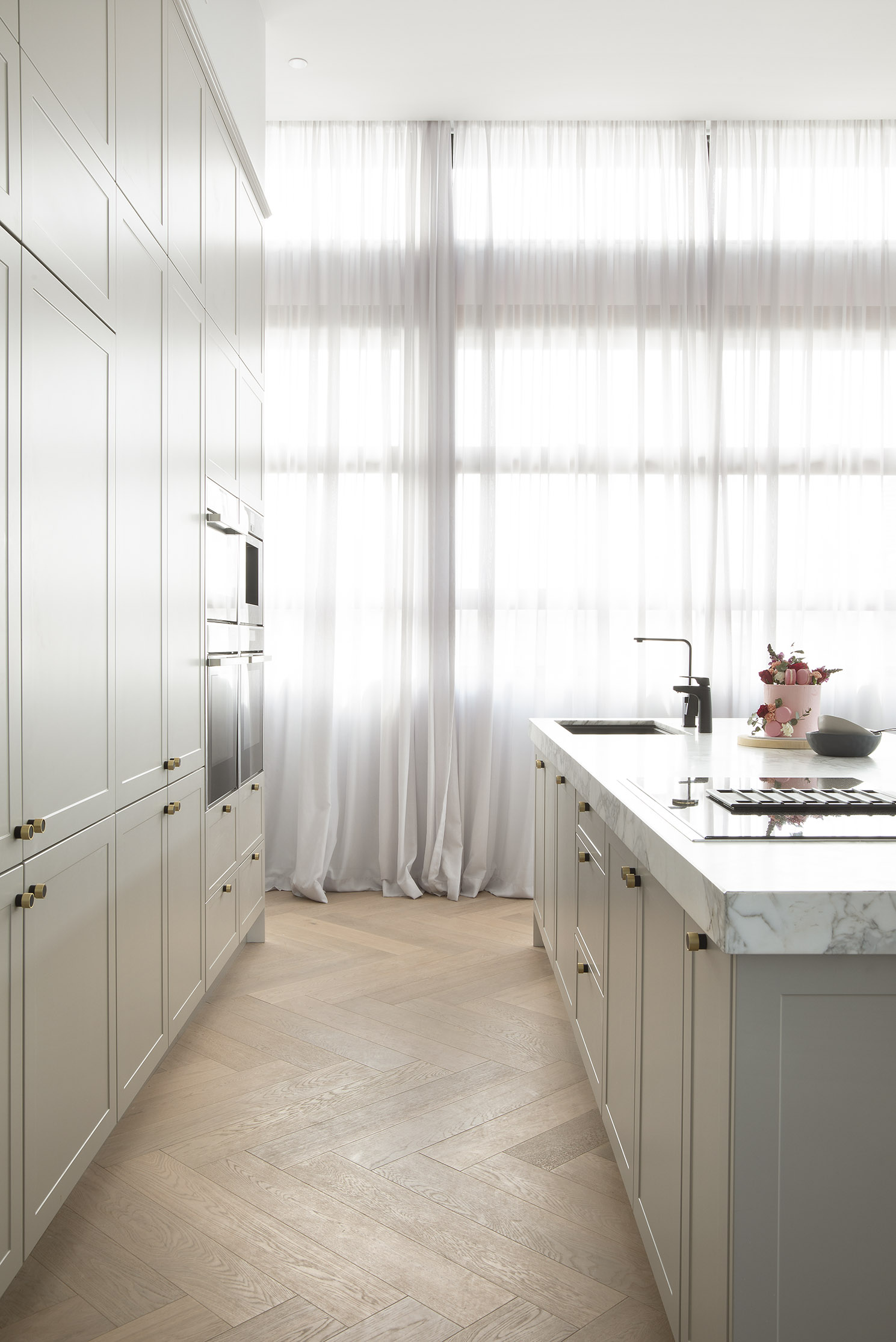 Kitchen with modern cabinetry and white island bench top.