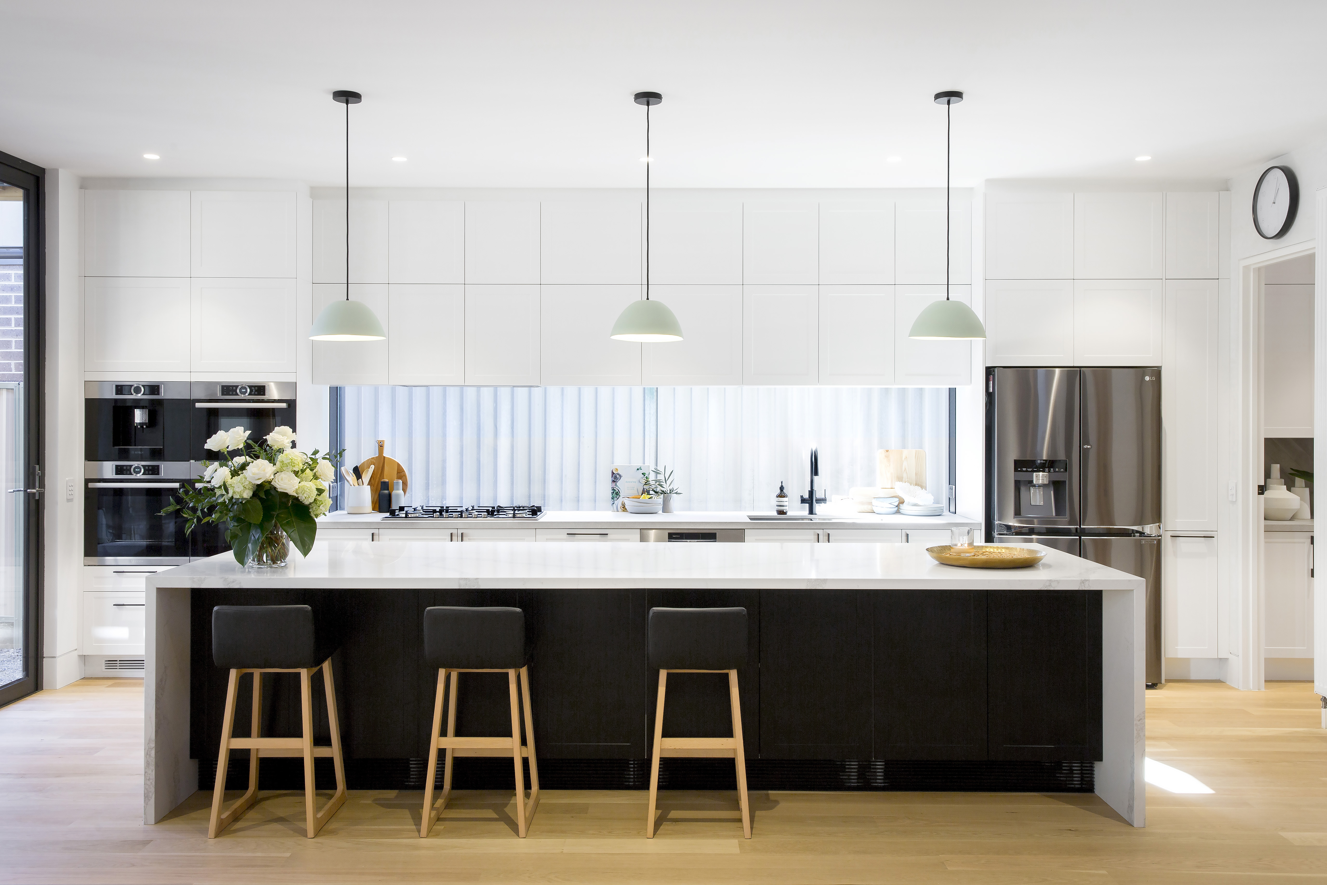 Kitchen with modern white cabinets and black island bench cabinets