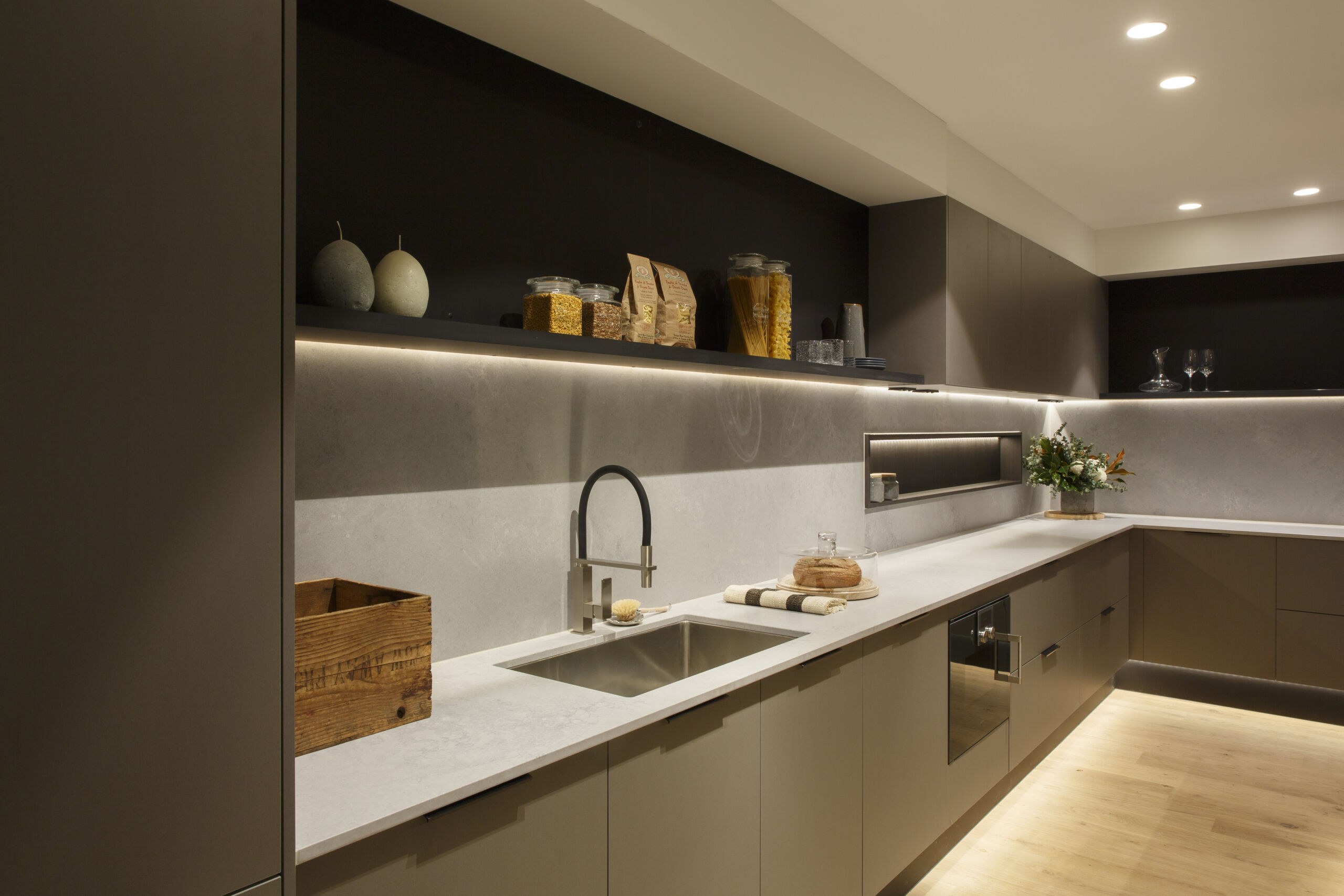 A dark butler's pantry with white benchtop and all the basic appliances