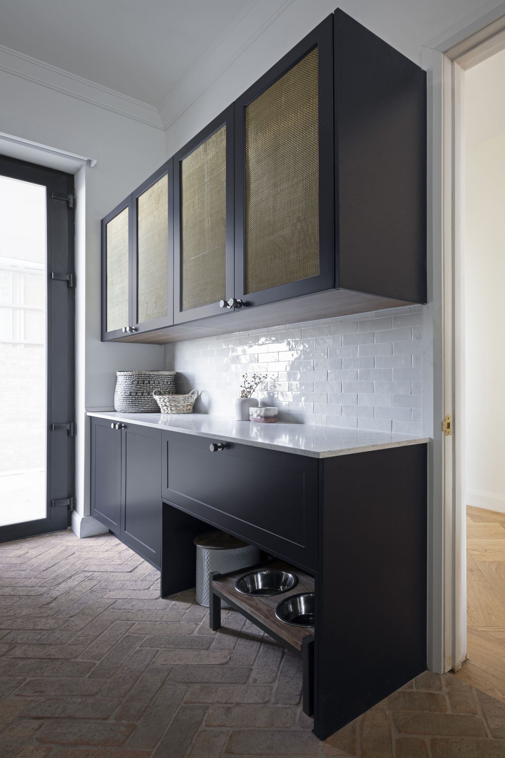 The Block 2022 Tom and Sarah-Janes mudroom showcases a modern country aesthetic with dark shaker style Sierra Oxford doors, Patina Brass Mess inserts and arched pet bed.