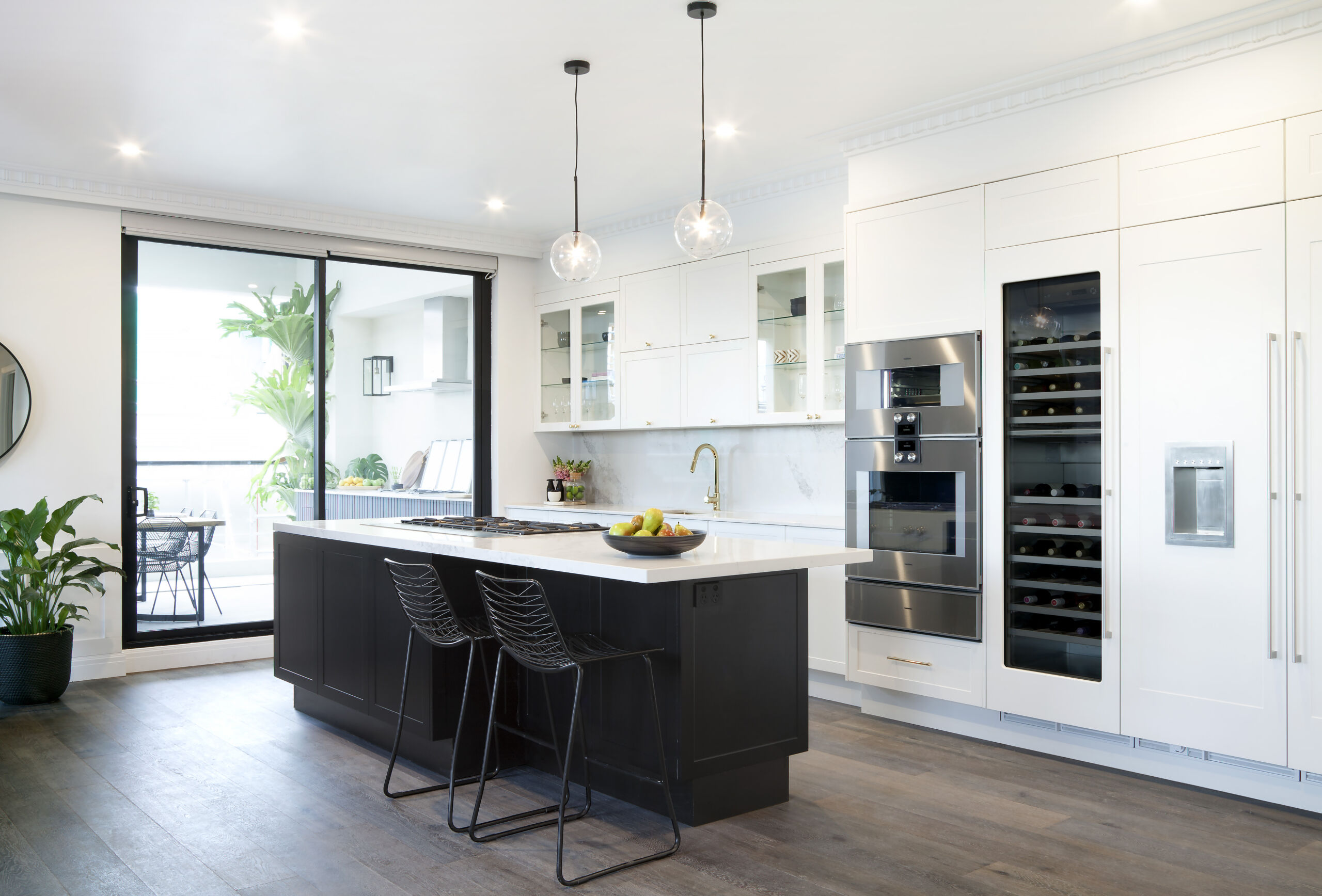 Black and white monochrome kitchen that is next to the outdoor space.