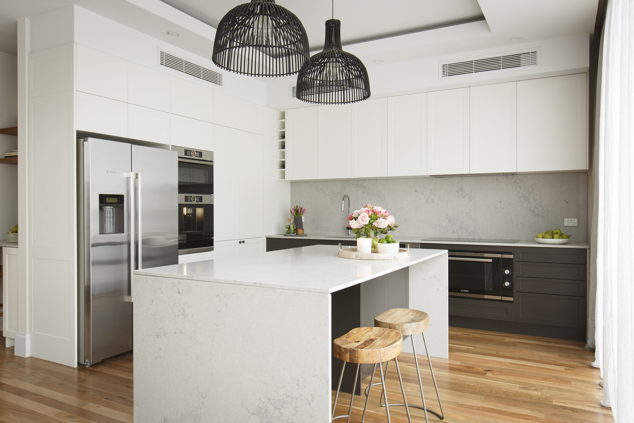 White and grey kitchen with large island bench with seating.