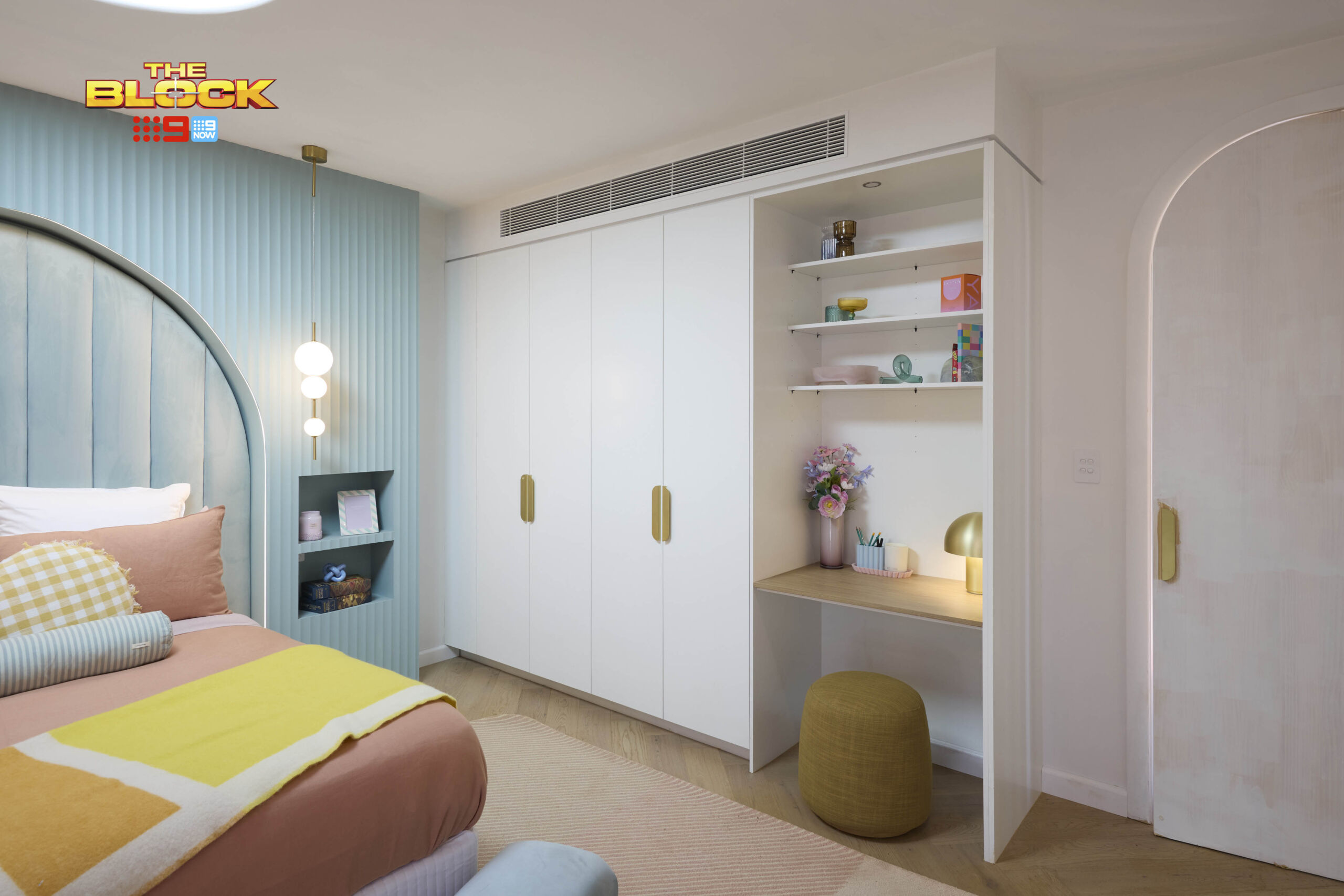 Kids bedroom with white built-in wardrobe, brass handles and built-in desk with open shelving