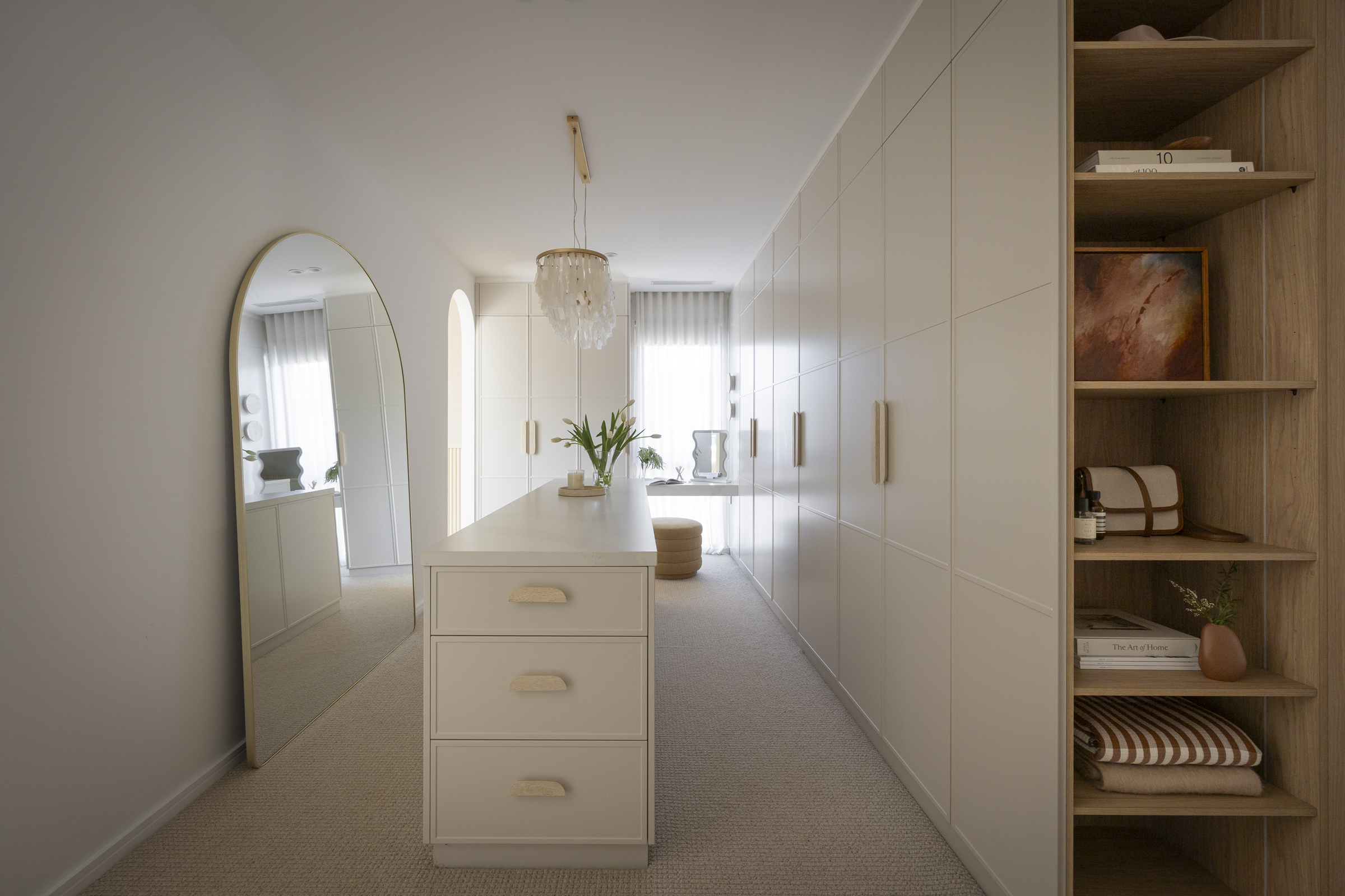 White and timber coastal walk in wardrobe with island bench