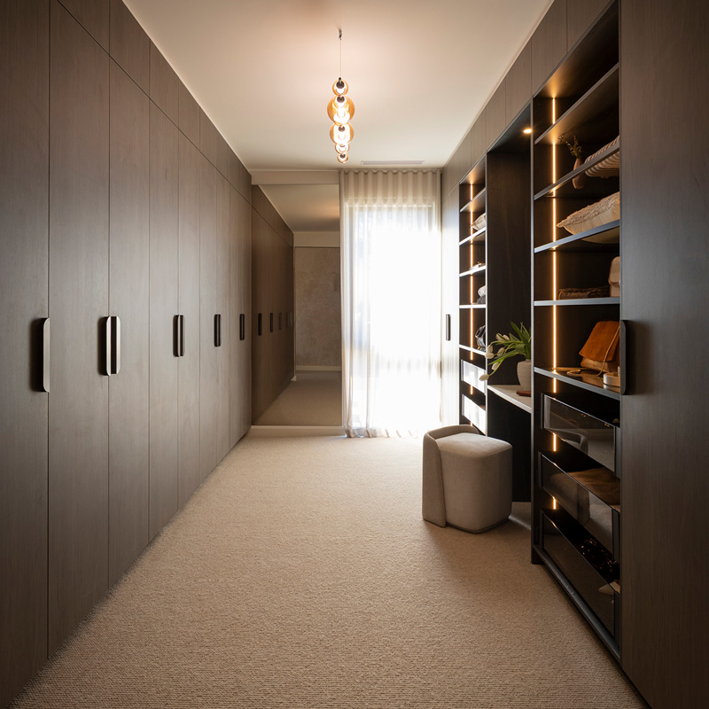 The Block 2025 – House 5 – Robby & Mat The Block 2025 - House 5 - Robby & Matt: Freedom Kitchens Block 26 reveal with dark timber walk-in wardrobe with open shelving, LED lighting, and upholstered ottoman.