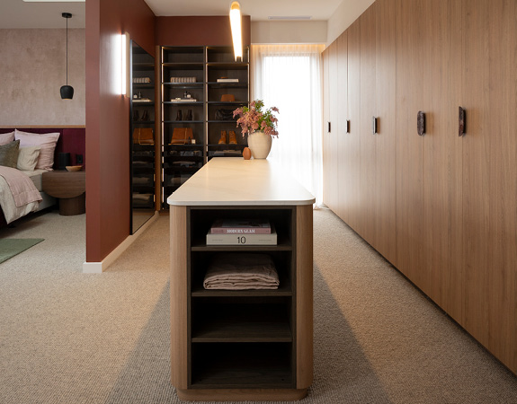 fk-block26-previous-2025 The Block 2025: Light timber wardrobe with island storage, dark display shelving, terracotta accent wall.