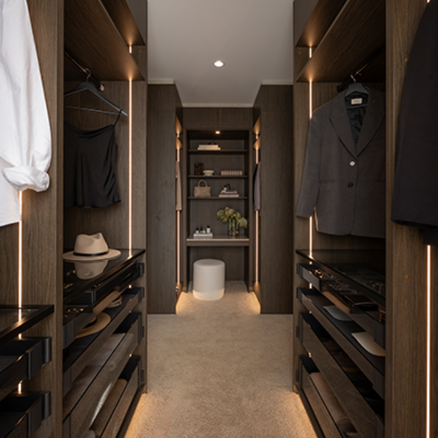 Walk in wardrobe with dark wardrobe open shelving and vertical strip lighting