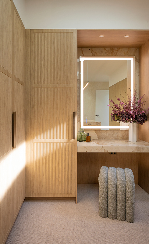 Illuminated dressing table with stone benchtop in Adam and Jolene’s walk in wardrobe