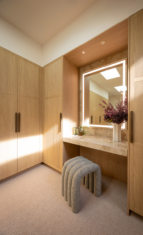 Illuminated dressing table with stone benchtop in Adam and Jolene’s walk in wardrobe