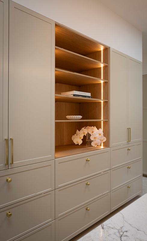 Greige shaker wardrobe cabinetry with Nordic Oak display shelving and brass handles
