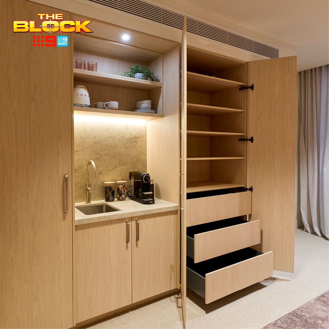 The Block 2026 – House 4 – Courtney and Sev Freedom Wardrobes built-in unit on The Block 2026, wardrobe door open to reveal internal shelving and pull-out drawers, beside a bar nook with sink and open display shelving.
