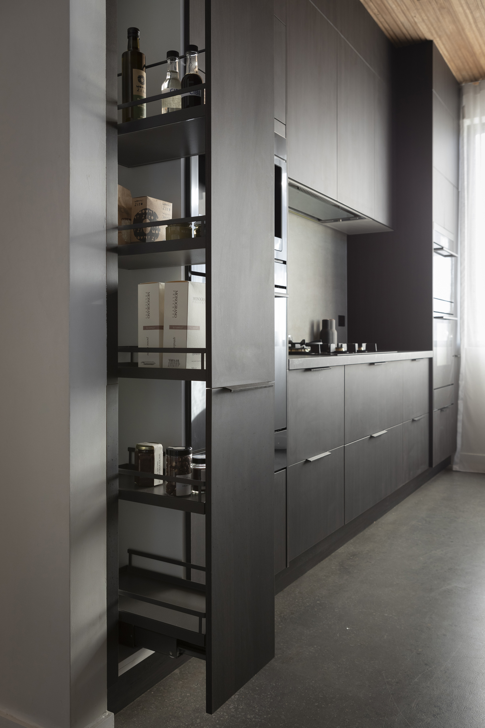FM_MA156 Pull-out pantry in dark cabinetry in an industrial style kitchen