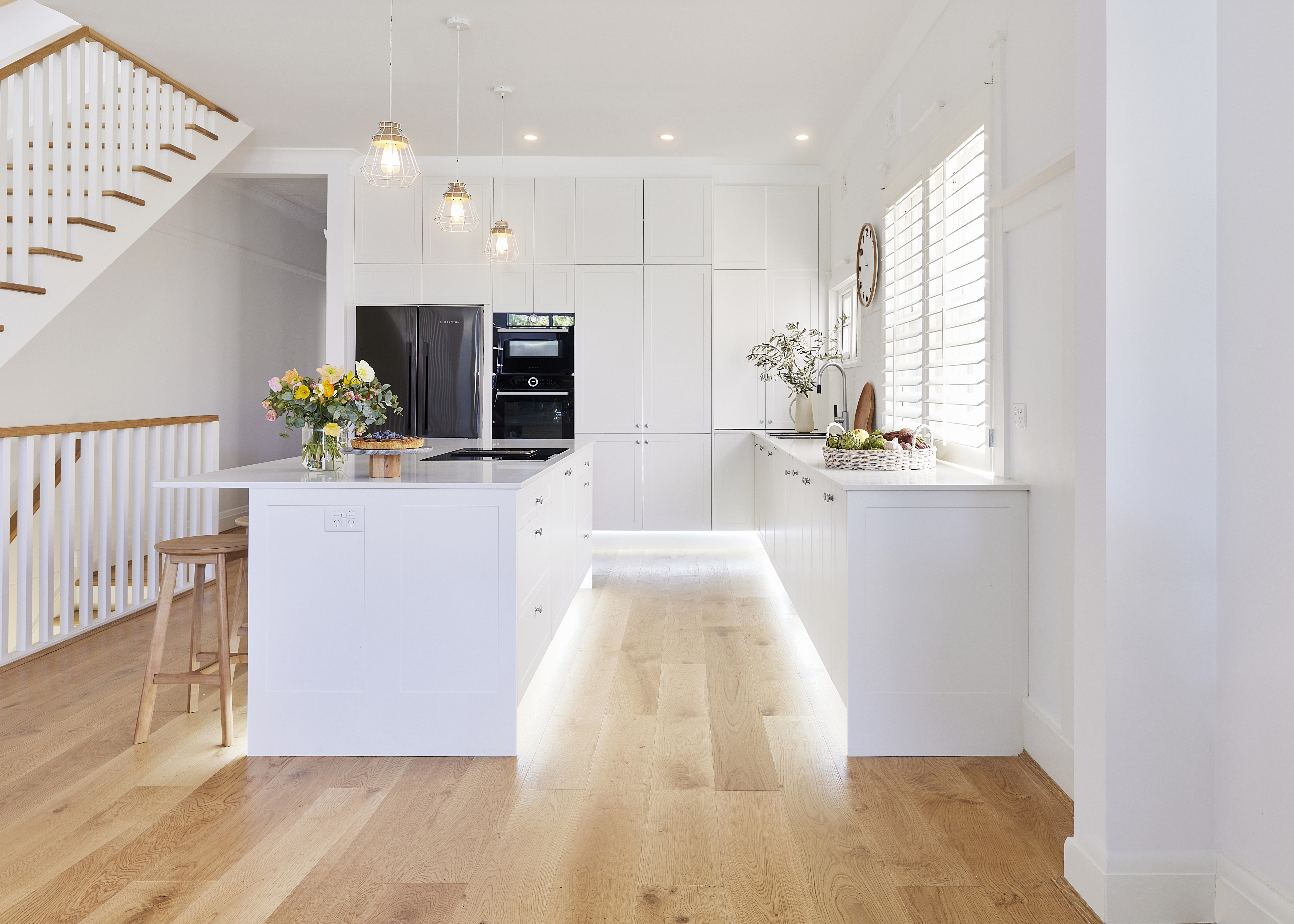 Front_Hero_Lights_On_Landscape Large white L-shaped kitchen with lots of storage and a large kitchen island bench