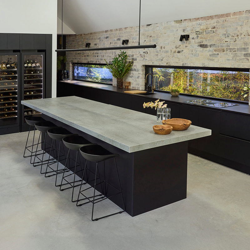 industrial-oct26-mob-1 Industrial style kitchen with exposed brick wall, black cabinetry, stone island benchtop and built-in wine fridges